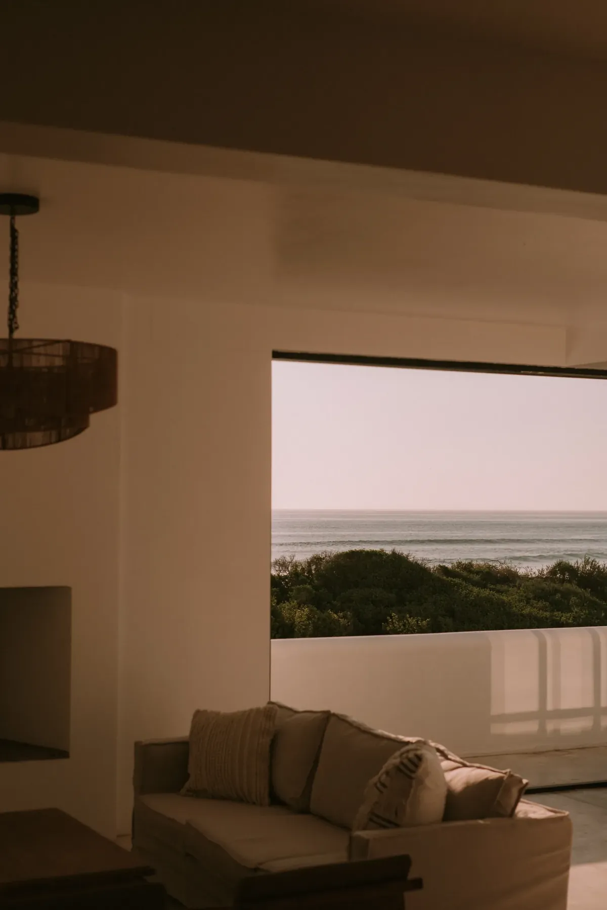 The lounge, with a sofa beneath a wide window onto the ocean