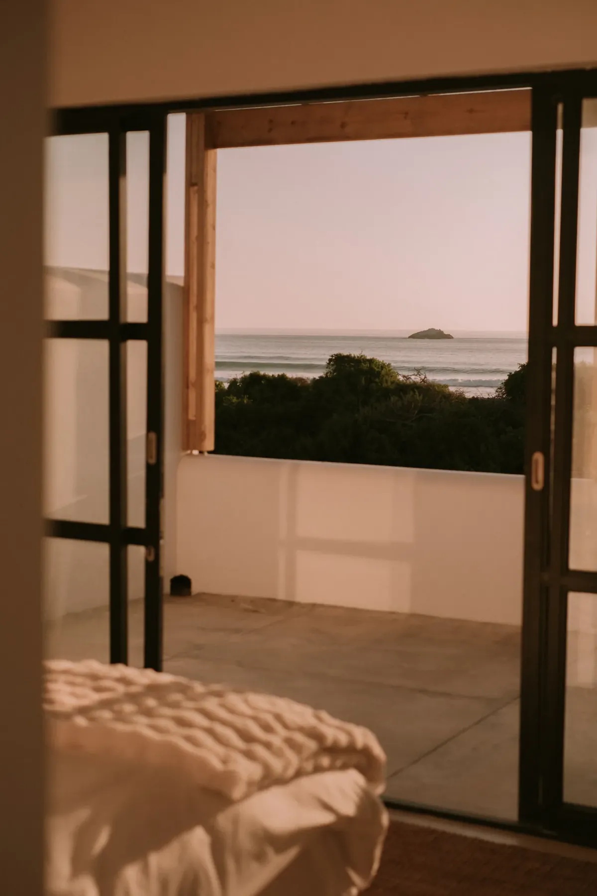 Sea views through the bedroom’s open steel-framed doors