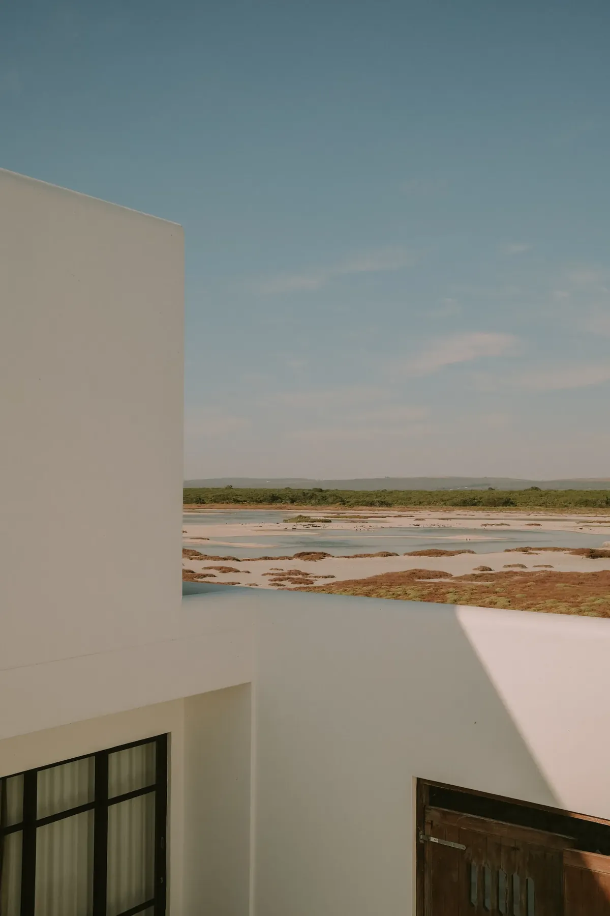 The salt pans seen over a whitewashed corner of the villa