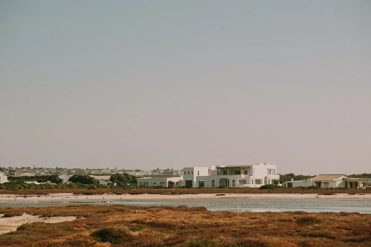 The villa, a white two-storey house, seen across the salt pans